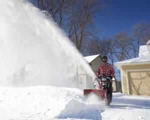 Toro battery powered two stage snow blower clearing driveway
