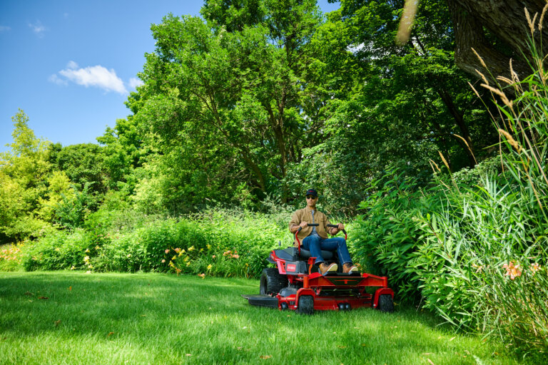 Toro Titan MyRide zero turn mower cutting grass next to a flower bed
