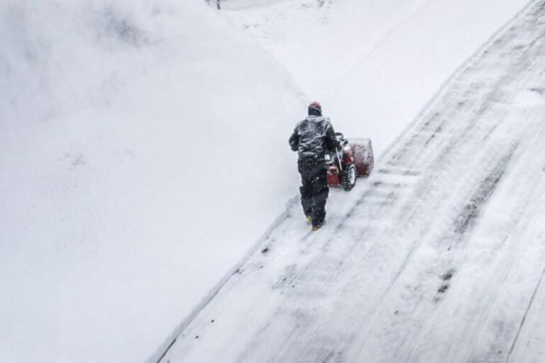 man clearing large driveway from snow with Toro 60V Power Max snowblower