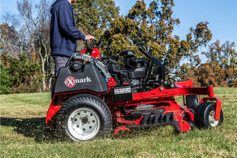 Side view of an Exmark Vertex stand on mower cutting grass