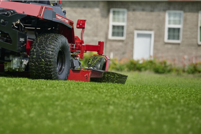Close up rear side view of Toro TimeCutter zero turn mower cutting grass in large lawn