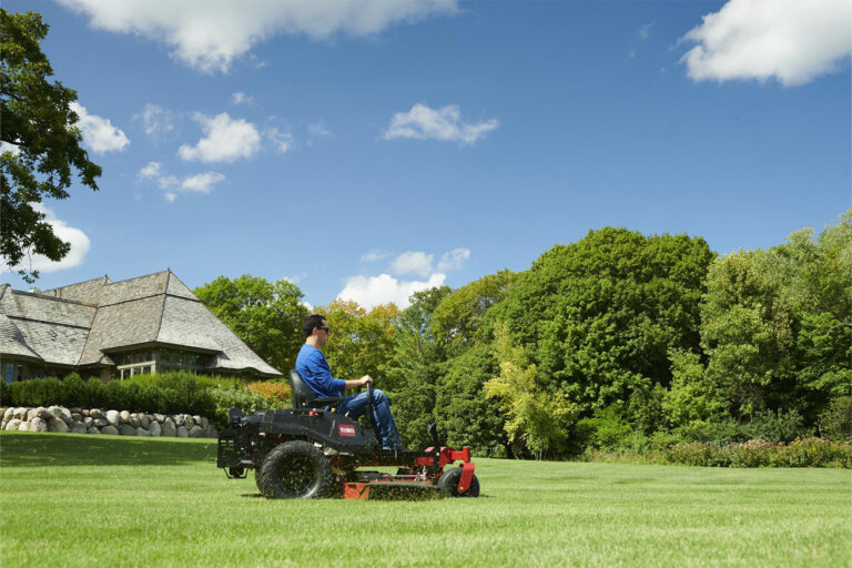 Man riding a Toro Titan zero turn mower cutting a large lawn