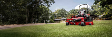 Exmark Lazer zero turn riding mower in front of house