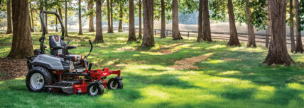 Exmark zero turn riding mowers in a yard with trees