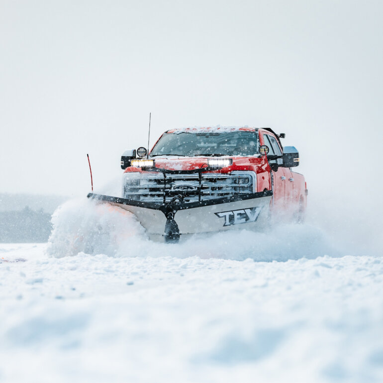 BOSS TEV snow plow on red truck plowing snow