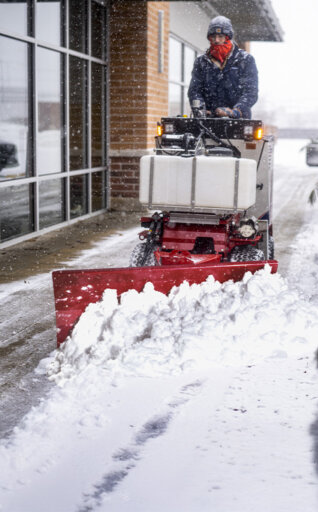 Ventrac sidewalk snow vehicle clearing snow on a sidewalk