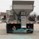 Snowex Renegade salt spreader in the bed of a large dump truck spreading salt