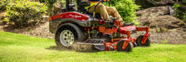 Close up view of an Exmark zero turn mower cutting grass