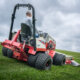 Rear view of a Ventrac 4520 PRO tractor with dual wheels and mower attachment mowing grass on a hill
