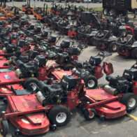 large display of used Exmark walk behind mowers in a lot