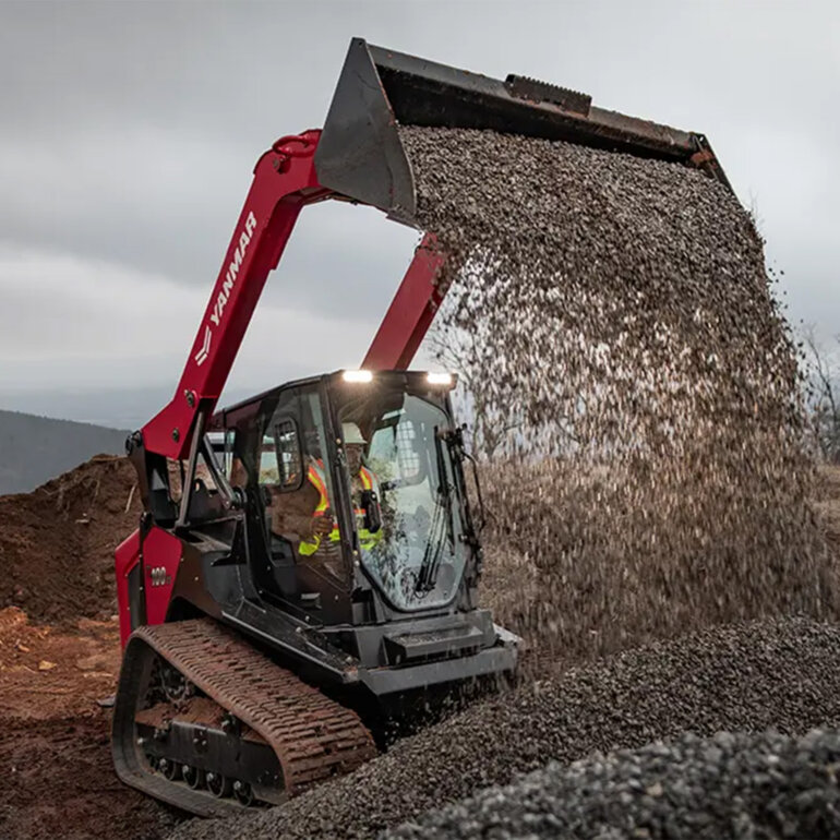Yanmar TL100VS track loader with a bucket attachment dumping gravel at a job site